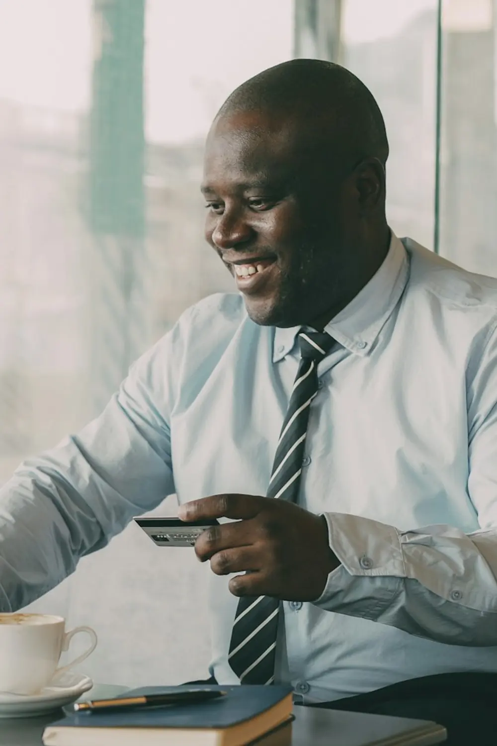 Businessman holding a credit card while making an online payment